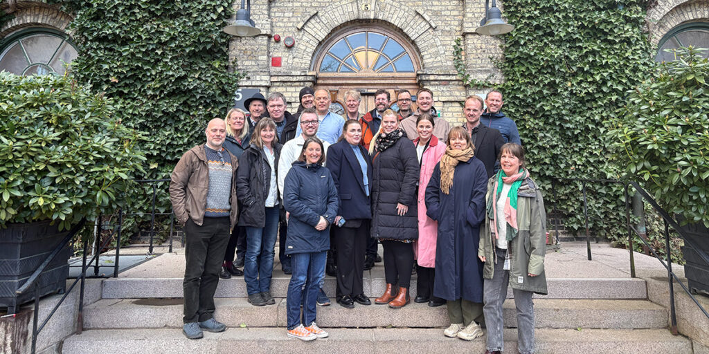 Gruppfoto av deltagarna i ett projekt på trappen av en stenbyggnad.