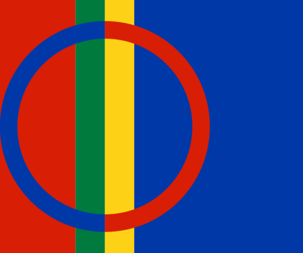 Samiska flaggan visas med röd bakgrund och ett stort ringmotiv i mitten: vänster halva av ringen är blå, höger halva röd, över en vertikal grön och gul rand, samt blått fält till höger.