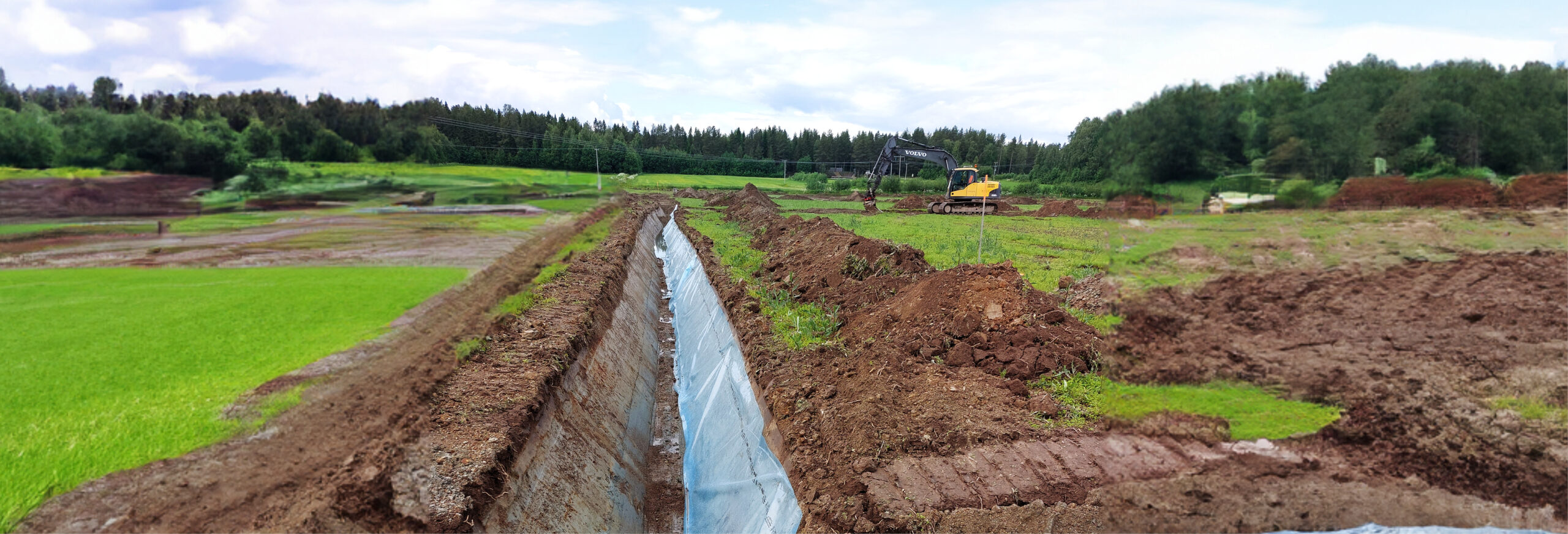 Grävmaskin gräver och formar en lång, rak dikessträcka med plast- eller dukklädd slänt. Jordmassor ligger i högar längs kanten, i ett öppet fält med skogsridå och molnig himmel i bakgrunden.