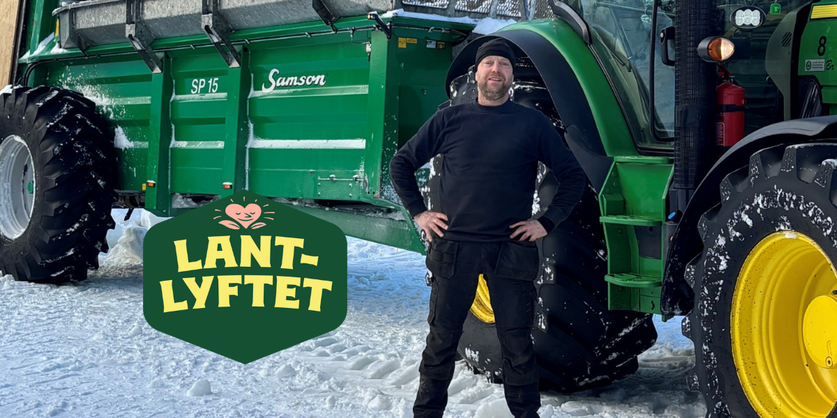 Man i svarta arbetskläder står med händerna på höfterna framför en stor grön traktor och vagn i snöig miljö. Logotyp med texten “LANTLYFTET” syns i förgrunden. På vagnen står “Samson” och “SP 15”.