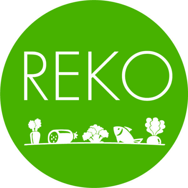 Grön cirkelformad logotyp med vit text “REKO”. Längs nederkanten syns vita ikoner av grönsaker och fisk på en linje, vilket signalerar lokal mat, odling och försäljning i REKO-ring.