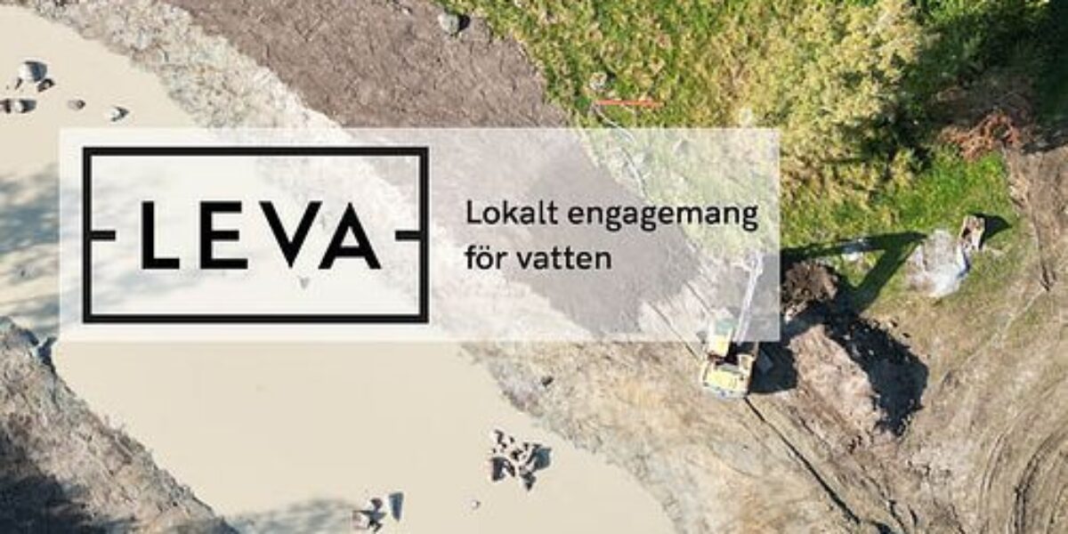 Flygvy över en utgrävd damm med ljus sandig botten där en grävmaskin arbetar vid kanten, omgiven av gräs och träd. Överlagrad text: “FLEVA” och “Lokalt engagemang för vatten”.