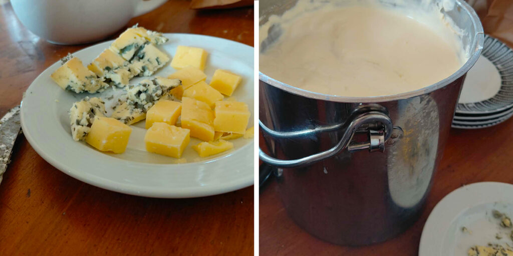 Tallrik med ostbitar, både gul ost och mögelost, står på ett träbord för provsmakning. Bredvid syns en stor metallhink fylld med ljus, krämig ostmassa eller gräddig blandning under studiebesök.