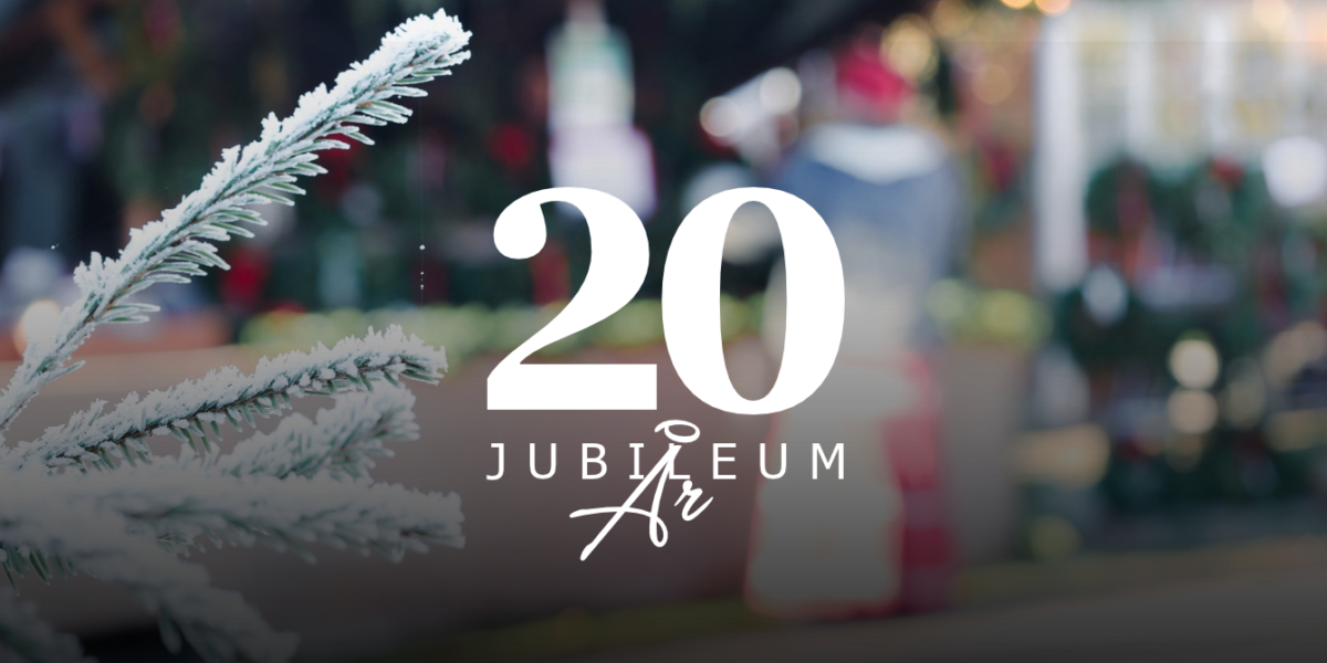 Snötäckt grankvist i förgrunden och suddig julmarknad med ljusslingor i bakgrunden; över bilden ligger texten “20 JUBILEUM År”, som markerar 20-årsjubileum i en vinterlig, festlig miljö.